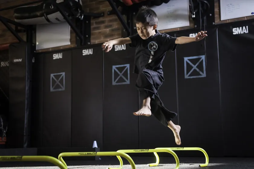 A Little Dragons student clearing training hurdles at speed