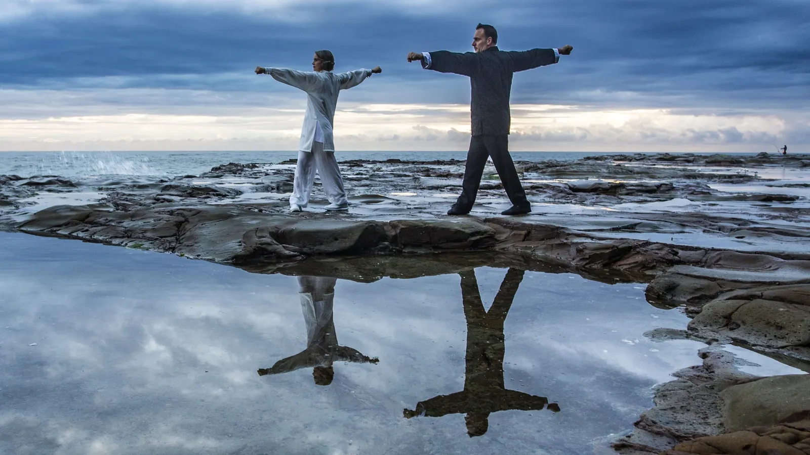 Grant Mundy and a student practising Meihuaquan at dawn on the rocks at Avoca Beach